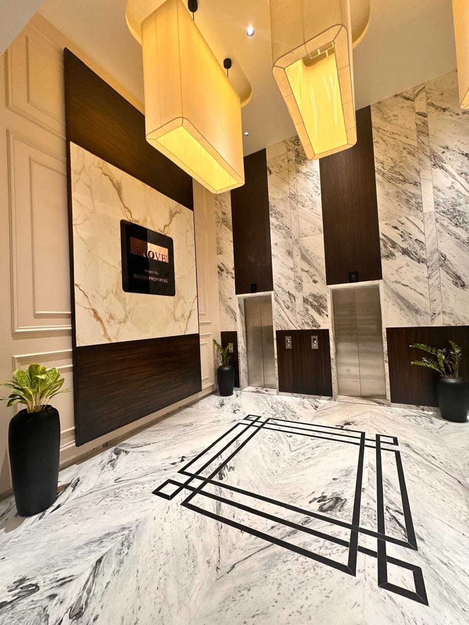 Modern commercial space interior design with marble flooring and stylish elevator area, designed by Metamorphic Designs, Pune